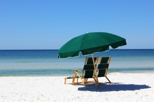 two chairs and umbrella on white sand beach